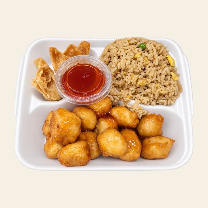 Orange chicken lunch plate with fried rice, crab rangoon and sweet and sour sauce